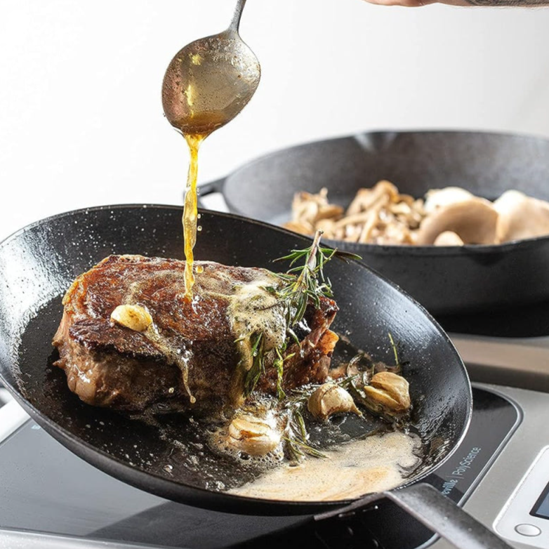 The images shows that a meat of some kind is being prepared over the Breville Control Freak induction cooking system. 